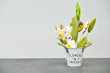A gift pot with gingerbread in the form of flowers stands on a gray table and on a gray background