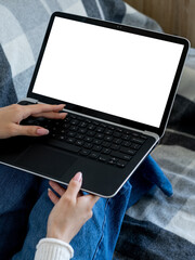 Home education. Digital technology. Advertising mockup. Unrecognizable woman typing laptop with blank screen holding on knees in room interior.