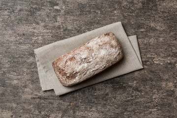 Fresh rye bread on napkin on rustic background, fresh bread top view
