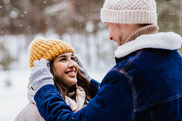 people, love and leisure concept - happy smiling couple looking at each other in winter forest