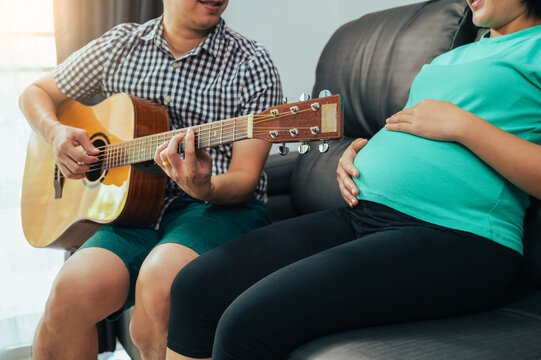 pregnant woman listen her husband play guitar 