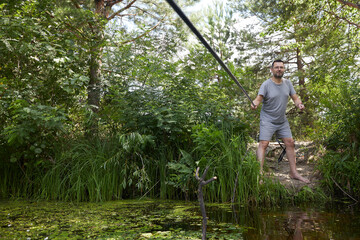 Caucasian adult man fishing on the river with beautiful view of landscape.