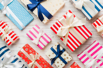 Fototapeta premium A lot of Christmas gift boxes in colored paper decorated on table, Top view close up. Many present New Year gift