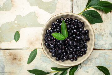 Wild berries, Northern berry: lingonberry, blueberry, Bowl of fresh maqui berry on light background, top view
