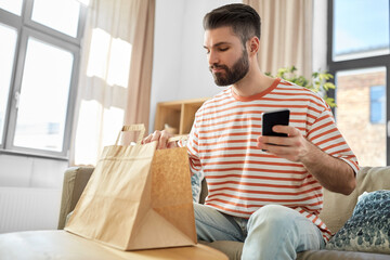 communication, leisure and people concept - man using smartphone for takeaway food order check up...