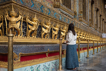 Traveler woman at Wat Phra Kaew, Emerald Buddha temple, Bangkok Thailand.
