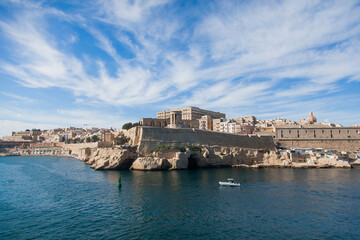 Fototapeta na wymiar View of Malta from the water with old buildings near the water.