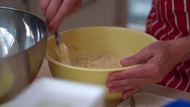 Hands Mixing Potato Dough And Flour In A Bowl. Making Bryndza Dumplings In The Kitchen. close up