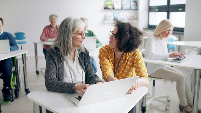 Group of senior people attending computer and technology education class.