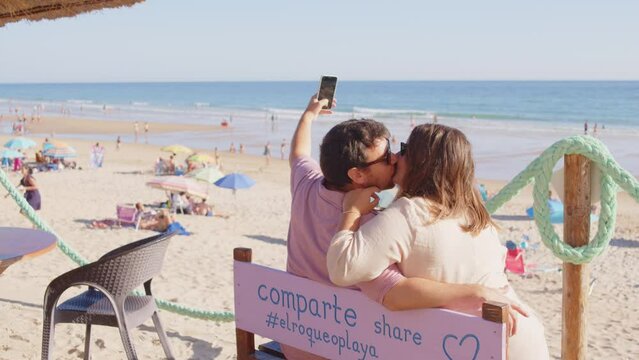 A lovely couple taking some selfies at the viewpoint of the beach of Conil de la Frontera, Cádiz