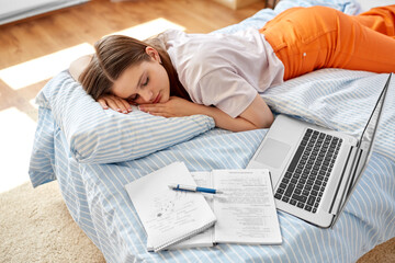 school, education and laziness concept - tired teenage student girl with laptop computer and...