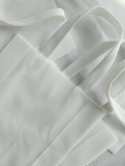 white non-woven fabric tote bag. collection . pile of textured and strappy polypropylene material....