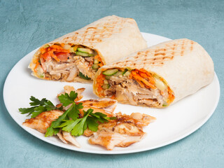 shawarma with chicken and vegetables on a blue background. Close-up