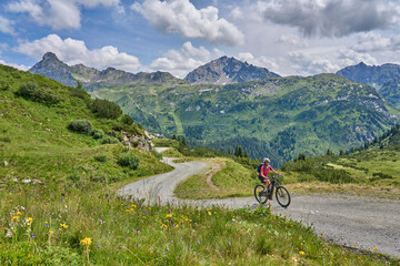 nice active senior woman riding her electric mountain bike in the silvretta mountain range near...
