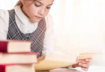 schoolgirl reading a book close-up in the library