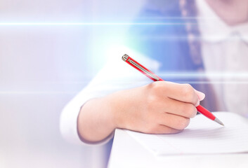 hand of a schoolgirl writes with a bright pen in a notebook close-up