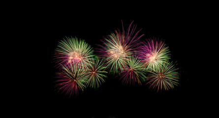 Colorful magical fireworks showing on sea in celebration festival with city lighting and black sky...
