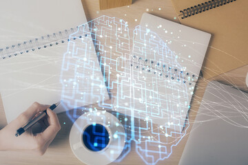 Multi exposure of woman's writing hand on background with brain hologram. Concept of brainstorming.