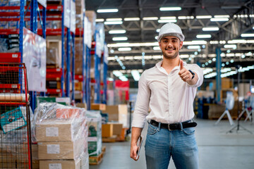 Warehouse worker or manager stand with smiling and show thumbs up to camera in workplace. Concept of professional factory worker support for delivery and transport system.