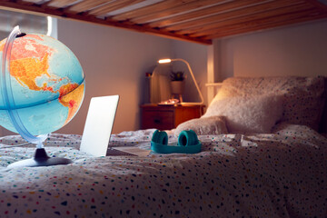 Inside Child's Bedroom At Night With Laptop Headphones And Globe On Bunk Bed