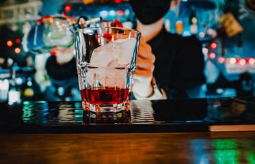 woman hand bartender making negroni cocktail in bar