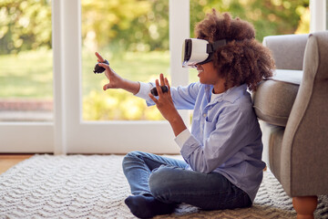 Boy Sitting On Floor In Lounge Wearing VR Headset Playing Game