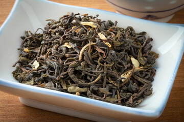 Dried Chinese Jasmine tea leaves close up in a bowl