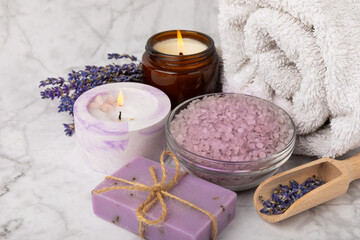 Fototapeta na wymiar Lavender spa.Sea salt, lavender flowers, aroma candle, body cream and handmade soap.Natural herbal cosmetics with lavender flowers on marble background.Relax concept.Beauty treatments.Copy space. 