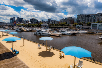 Artificial sandy beach on the bank of St. Laurence river in Montreal Old Port, summer season in Montreal, Quebec, Canada