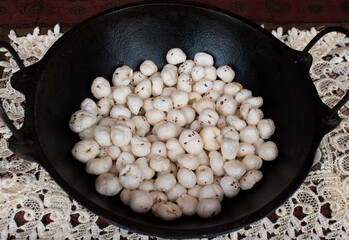 Crispy Lotus pops Seeds or Phool Makhana or Fox Nuts popular dry snacks from India served in a cast Iron. Side view. Makhana from Mithila region of Bihar in India. Mithilanchal. selective focus