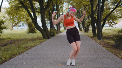 Athletic fitness sport runner girl training exercise, listening music on headphones dancing to...
