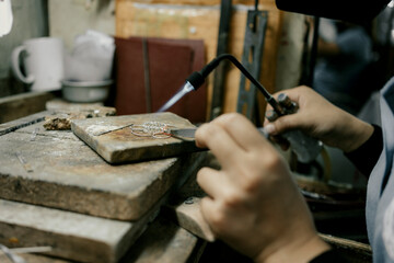 Jeweler at work in jewelry. Desktop for craft jewelry making with professional tools. Close up view...