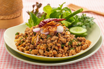 Spicy Thai minced duck salad with herbs and vegetables or Laab Ped served on a plate. Laab is one of popular menus from Isan or the northeast of Thailand. 
