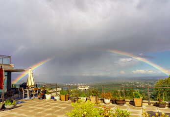 Full rainbow over Fraser Valley, BC, during flash rain shower - viewed from a patio in UniverCity...