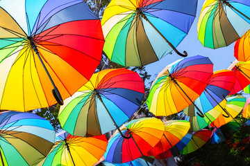 Multicolored umbrellas hanging above street in Istanbul in sunny day and blue sky