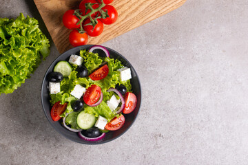 Greek salad with fresh tomatoes, cucumber, olives, feta cheese and red onion. Healthy and diet food concept.