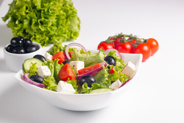 Greek salad with fresh tomatoes, cucumber, olives, feta cheese and red onion. Healthy and diet food concept.