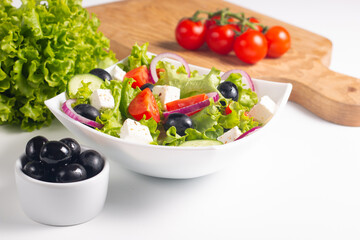 Greek salad with fresh tomatoes, cucumber, olives, feta cheese and red onion. Healthy and diet food concept.
