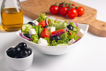 Greek salad with fresh tomatoes, cucumber, olives, feta cheese and red onion. Healthy and diet food concept.