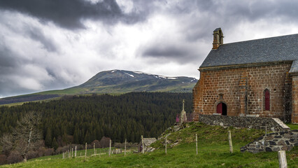 Panoramic landscape of volcanic mountains Massif Central and small picturesque chapel