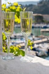 Two glasses of French champagne sparkling wine and view on colorful fisherman's boats in old harbour in Cassis, Provence, France