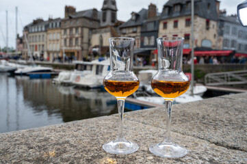 Tasting of apple calvados drink in old Honfleur harbour with boats and old houses on background, Normandy, France - obrazy, fototapety, plakaty