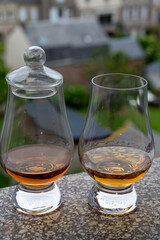 Two glasses of scotch whiskey with view on old houses on background, Edinburgh whisky tasting tour, Scotland