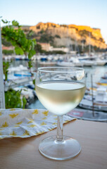 Cold white wine from Cassis region served in glass on outdoor terrace with view on old fisherman's...
