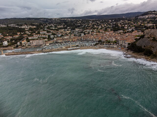 Panoramic aerial view on cliffs, beach, houses, streets and old fisherman's harbour with lighthouse in Cassis, Provence, France