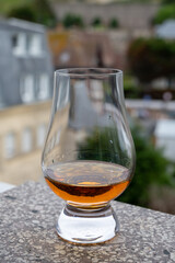 Glassof scotch whiskey with view on old houses on background, Edinburgh whisky tasting tour, Scotland