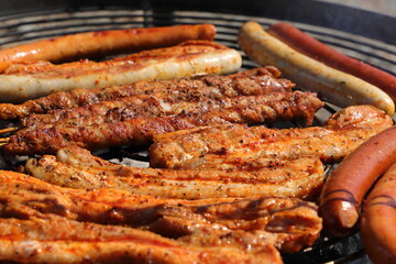 various meat and sausages on the charcoal grill