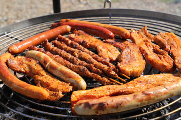 various meat and sausages on the charcoal grill
