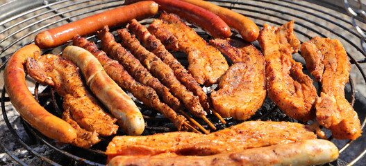 various meat and sausages on the charcoal grill
