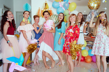Party and celebration. Group of happy smiling young women having fun together at home decorated with air baloons.
